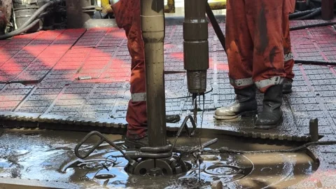 Rig crew perform pulling of of hole drill string with oil based mud Stock Footage 342082011