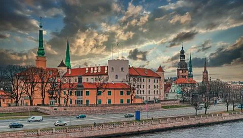 Riga Castle under dramatic sky on the banks of Daugava river . Panoramic view. Stock Photos