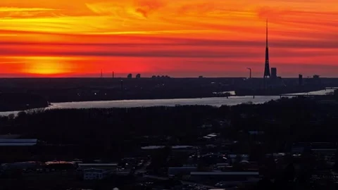 Riga city skyline with Daugava river and TV tower silhouette with fiery sunset Video stock 336812711