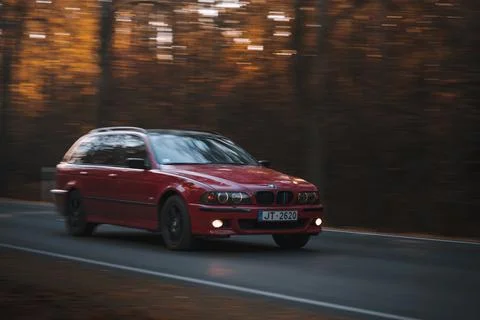 Riga, Latvia - 10 October 2021. Red 5 series BMW is driving on the street Stock Photos