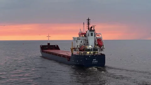 Riga, Latvia - May 3, 2026: Seagulls Fallowing Cargo Ship Leaving Port Stock Footage 334062881