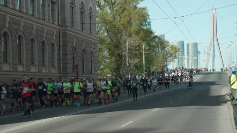 Riga Marathon 2023, crowd of runners run down from Vansu Bridge Stock Footage 240538706