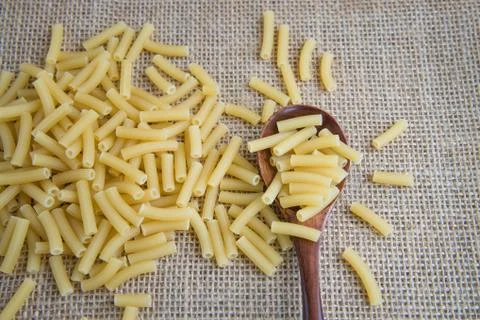 Rigatoni raw pasta on rustic background . Medium and Large tubes with square-cut Foto stock