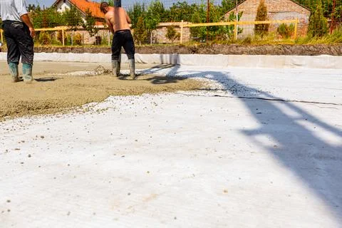 Rigger, worker is holding pump hose to pouring fresh concrete into building.. Stock Photos