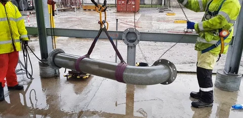 Riggers move the pipe using two chain blocks 動画素材 128932628