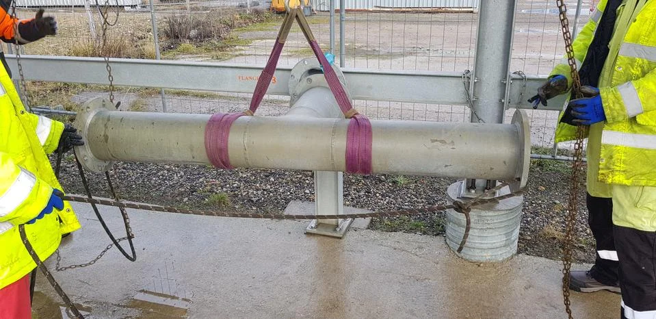 Riggers move the pipe using two chain blocks Stock Photos