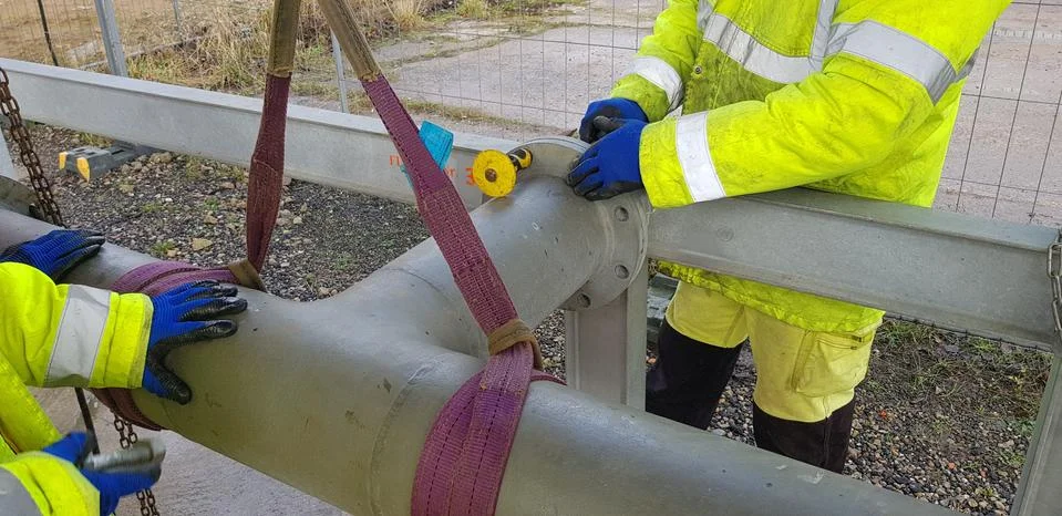 Riggers move the pipe using two chain blocks Stock Photos