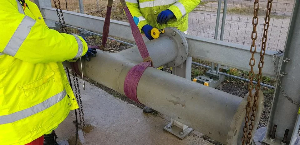 Riggers move the pipe using two chain blocks Stock Photos