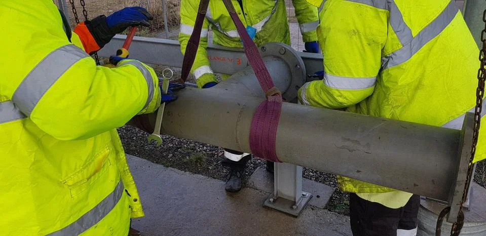 Riggers move the pipe using two chain blocks Stock Photos