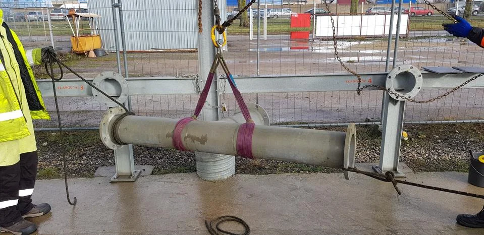 Riggers move the pipe using two chain blocks Stock Photos