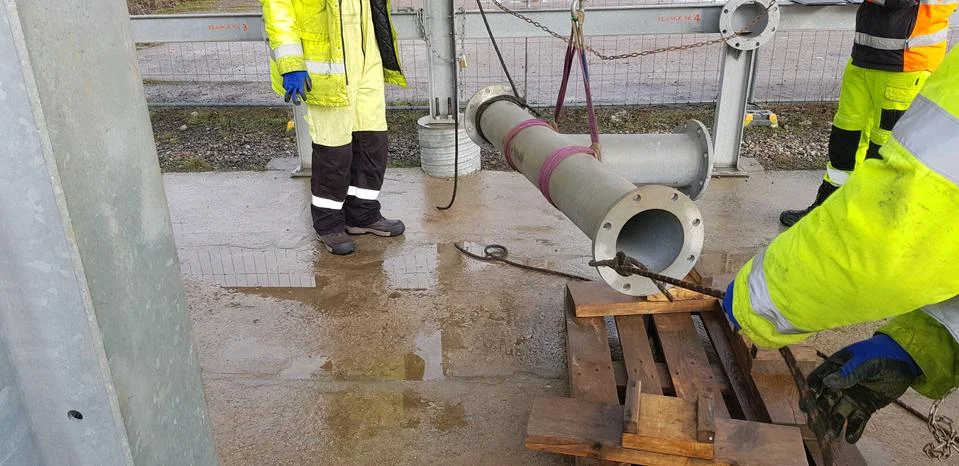 Riggers move the pipe using two chain blocks Stock Photos