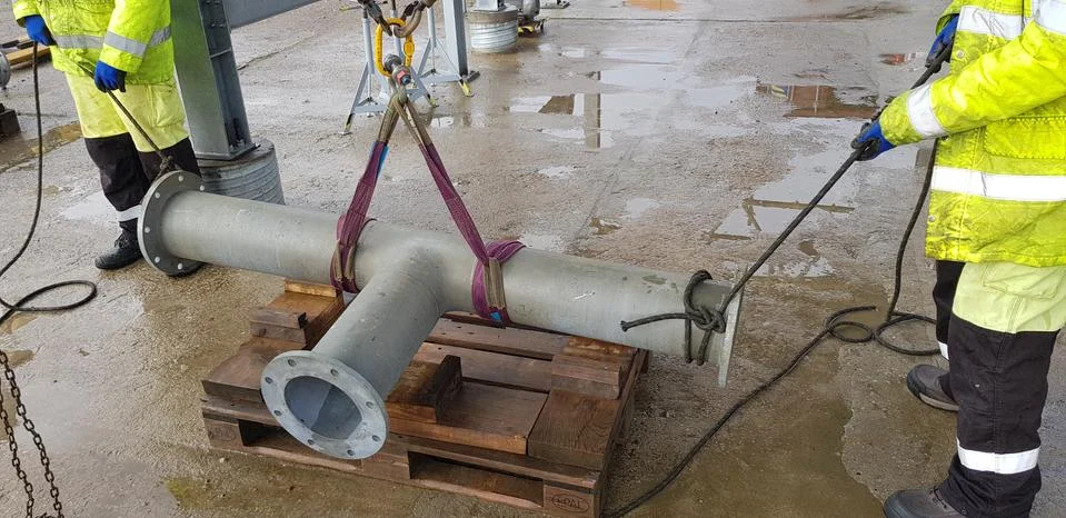 Riggers move the pipe using two chain blocks Stock Photos