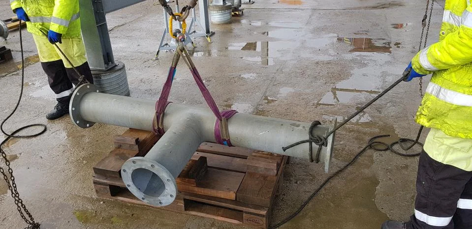 Riggers move the pipe using two chain blocks Stock Photos
