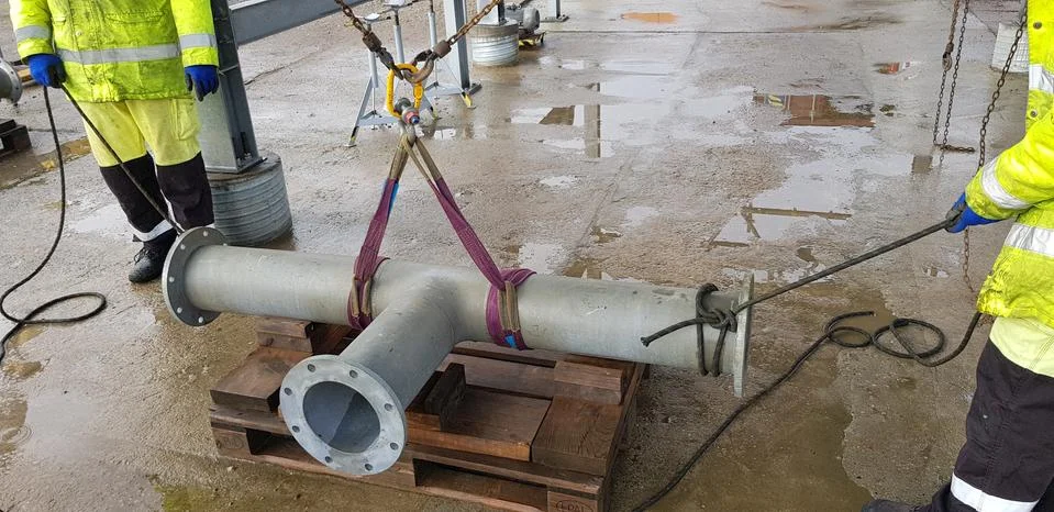 Riggers move the pipe using two chain blocks Stock Photos