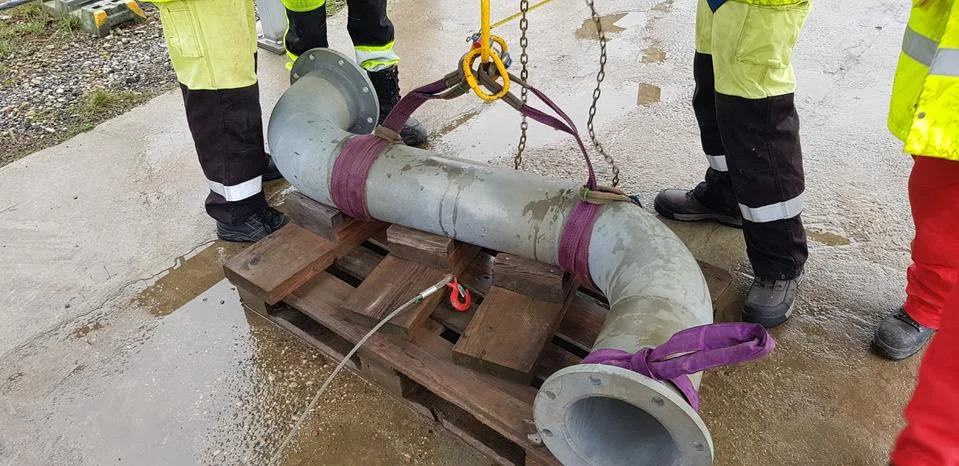 Riggers move the pipe using two chain blocks Stock Photos