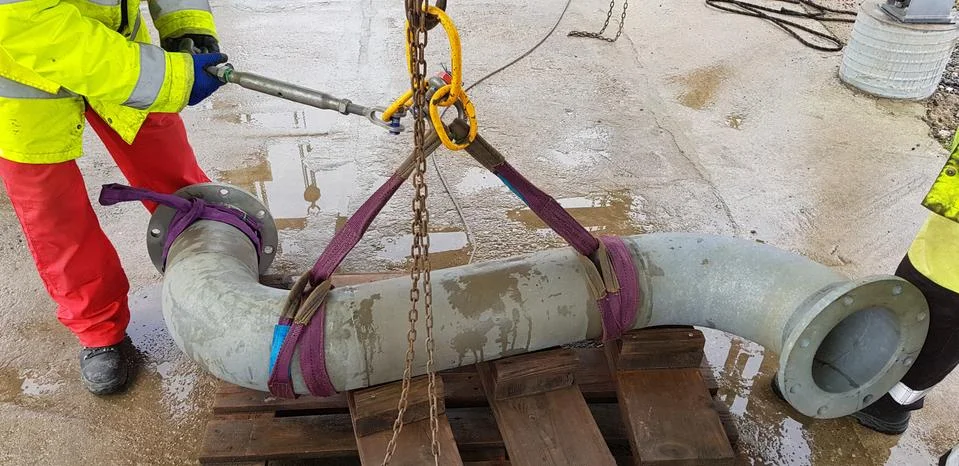 Riggers move the pipe using two chain blocks Stock Photos