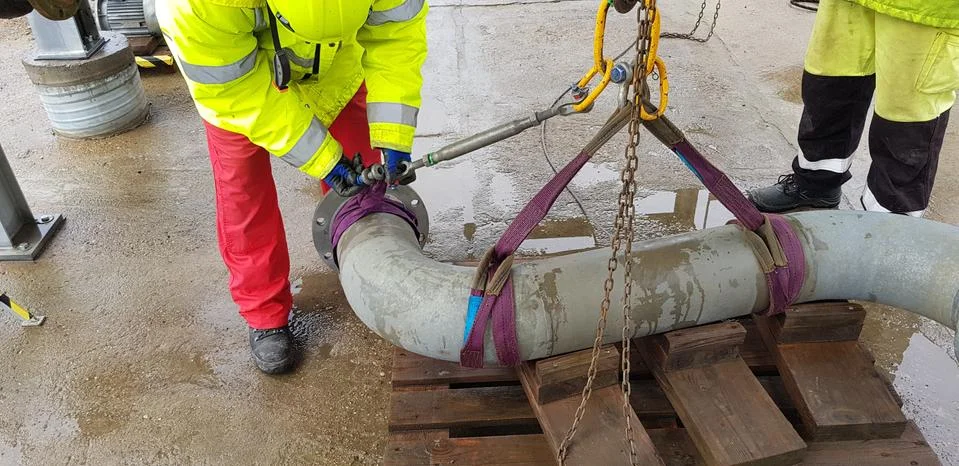 Riggers move the pipe using two chain blocks Stock Photos