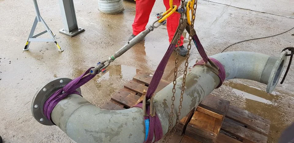 Riggers move the pipe using two chain blocks Stock Photos