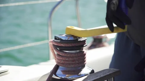 Rigging the mainsail. Close-up of sailor pulling the handle of a sheet winch. Stock Footage 240395260