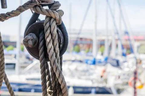 Rigging on the old sailboat against the background of modern yachts Stock Photos