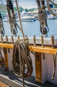 Rigging on the old sailboat against the background of modern yachts Stock Photos