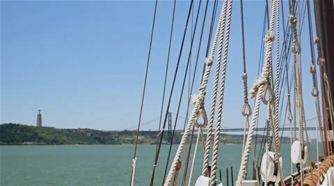 Rigging of sailing ship on background of bridge and statue of Jesus Stock Footage 64578605