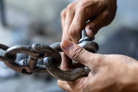 Rigging Worker Locking Steel Shackle Pin On Heavy Lifting Chain. Stock-Fotos