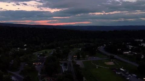 Right ascending pan of town at sunset and distant mountains Stock Footage 247428192