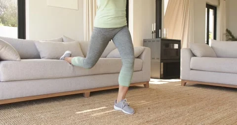 Right foot lifting onto sofa triggers woman performing split squats in living Stock Footage 335986475