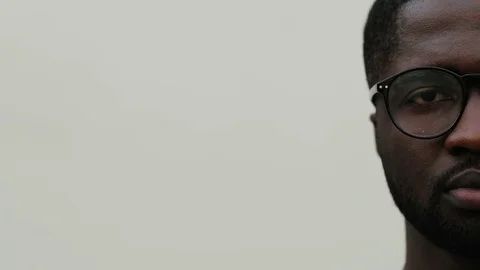 Right half of face of guy in glasses on white background. Young African man Stock Footage 81839435