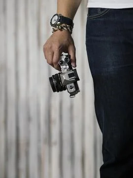 Right hand holding camera with watch and bracelet Stock Photos