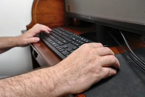 Right hand of a man holding a computer mouse and working on a desktop pc Foto stock
