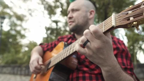 The right hand of a man moving over the guitar neck at park Stock-Footage 139294872