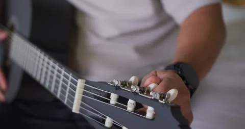 Right hand is turning white tuning peg after hearing low string pitch, tuning Stock Footage 337730696