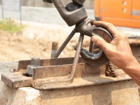 The right hand of the worker is holding the hook to fasten on the bracket for Stock Photos
