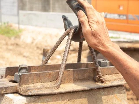 The right hand of the worker is holding the hook to fasten on the bracket for Stock Photos
