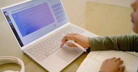 Right hand is writing notes, tapping screen after it shows 'Digital Marketing 動画素材 341025746