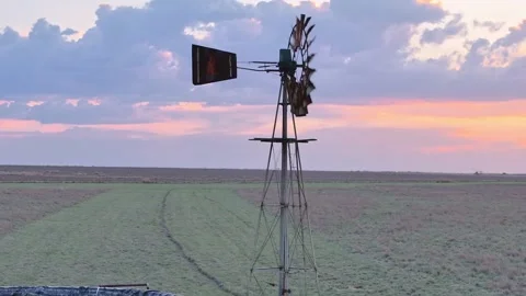Right to left circle shot of a turning windmill at sunset in South Africa Stock Footage 255614297