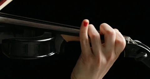 Right to left closeup pan on black electric violin played by hands Stock Footage 274865384