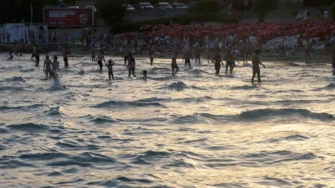Right to left pan crowd of people in beach swimming playing together in sea Stock Footage 90269048