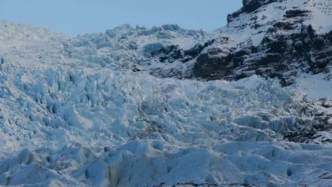 Right to left pan in a glacier with capped mountains Stock Footage 93969154