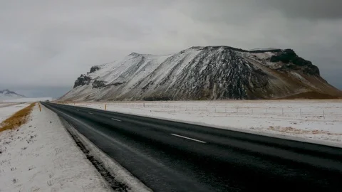 Right left pan from an isolated snowy mountain near road to landscape of Iceland Stock Footage 93616074