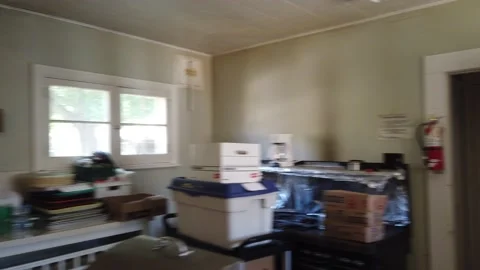 Right To Left Pan Of Messy Dirty Kitchen With Stacked Boxes Full Of Goods Stock Footage 165564159