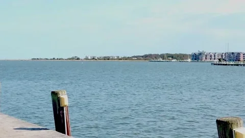 Right To Left Pan of Ocean Town To Reveal a Small Light House Stock Footage 231714786