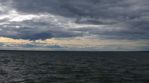 Right to left pan in an open sea with stunning clouds in the sky during sunset Stock Footage 99257361