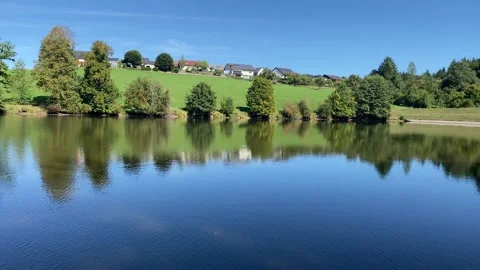 Right-to-Left Pan Over Sunlit Lake with Gentle Ripples in 4K Video stock 317583708