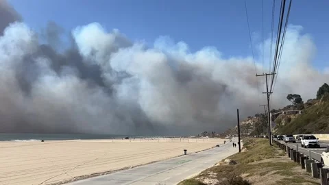 Right-Left Pan from PCH to ocean as smoke from Palisades Fire blows out to sea. 動画素材 297318893