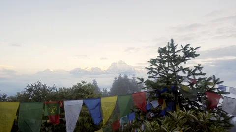 Right to left with prayer flags and Himalayan mountains above the clouds Video stock 91434325
