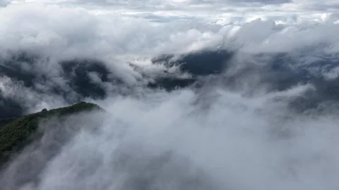 Right to Left Revolving Drone Shot of Misty Mountain Peaks and Clouds Stock Footage 345946391
