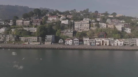 Right to left tracking of riverside houses with river foreground Vidéo 336792484
